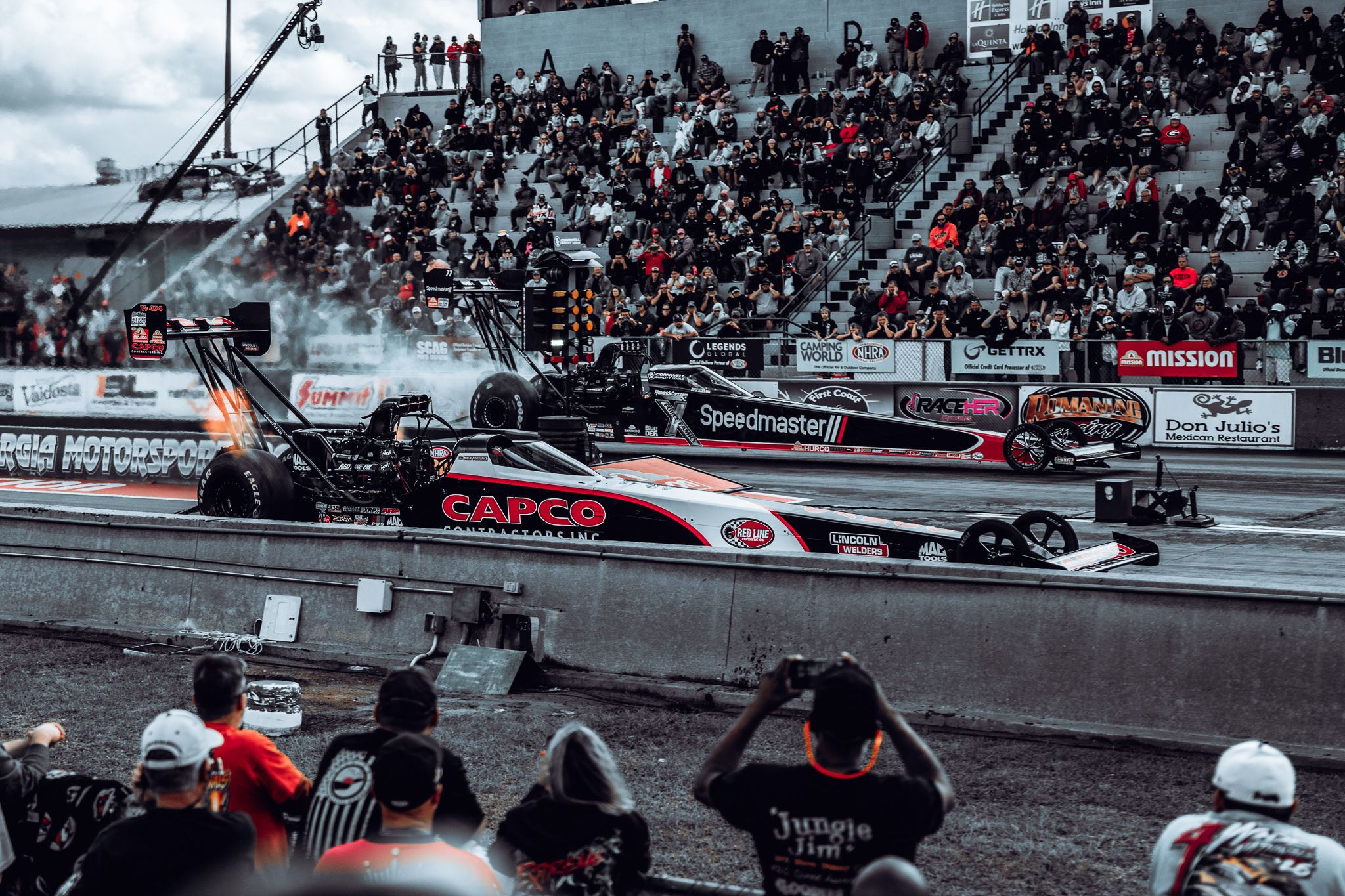 Two NHRA top fuel dragsters launching side by side